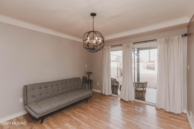 unfurnished room featuring an inviting chandelier and light wood-type flooring