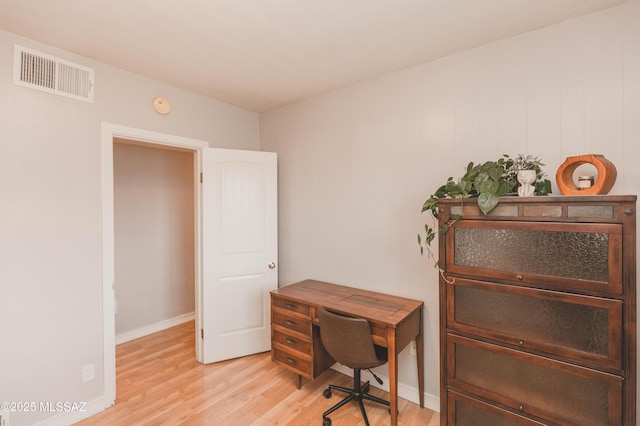 home office with light hardwood / wood-style flooring