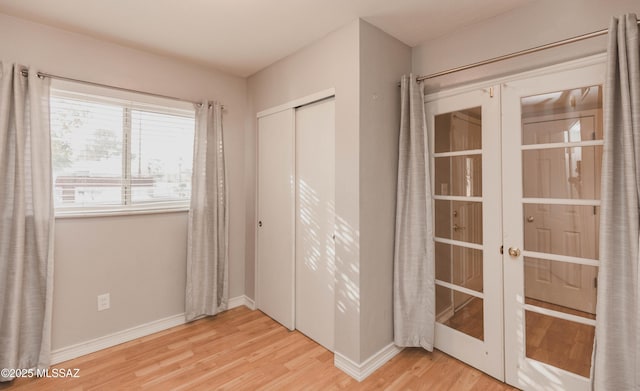 interior space featuring light hardwood / wood-style flooring, a closet, and french doors