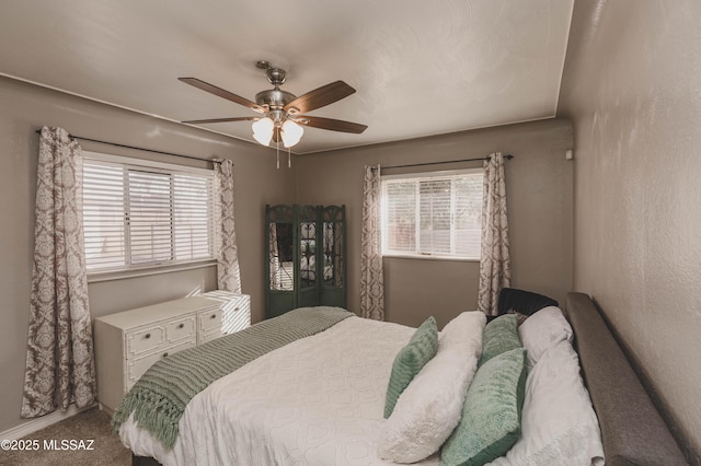 bedroom featuring multiple windows, carpet floors, and ceiling fan