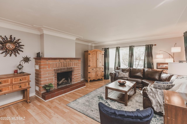 living room featuring a fireplace, ornamental molding, and light hardwood / wood-style floors