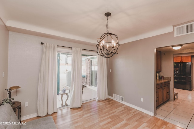 dining space featuring an inviting chandelier and light hardwood / wood-style flooring