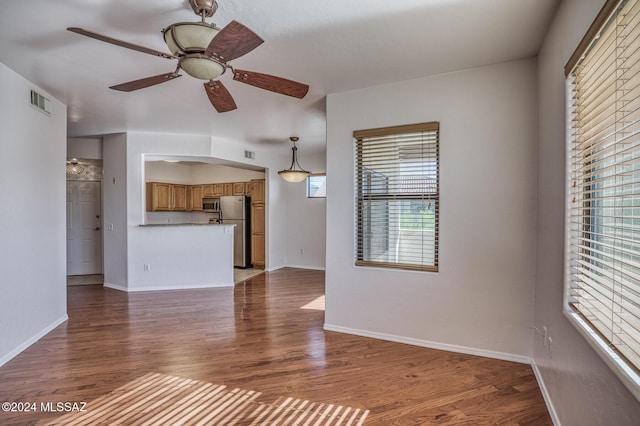 unfurnished living room featuring dark hardwood / wood-style floors and ceiling fan