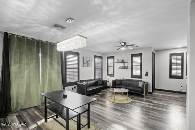 living room featuring wood finished floors, baseboards, ceiling fan, and visible vents