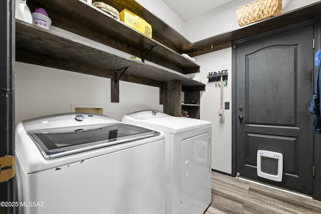 washroom with separate washer and dryer and light hardwood / wood-style flooring