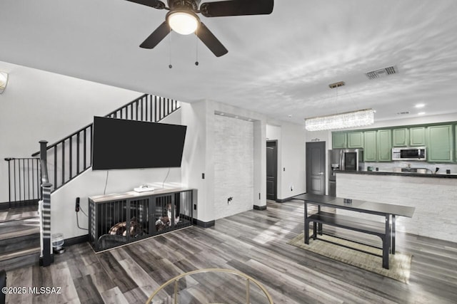 living area with stairway, baseboards, visible vents, a ceiling fan, and wood finished floors