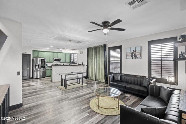 living room featuring ceiling fan and light hardwood / wood-style floors