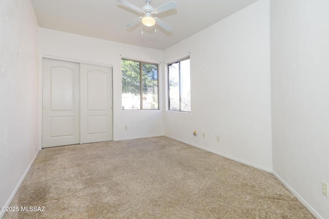 unfurnished bedroom featuring light carpet, a closet, and ceiling fan