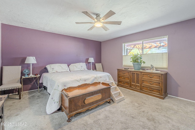 bedroom featuring light carpet, a textured ceiling, and ceiling fan