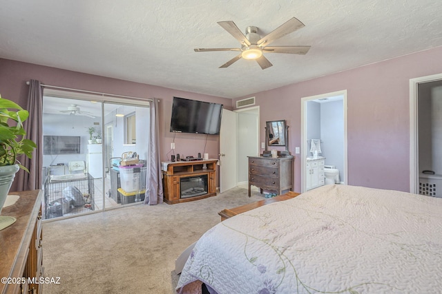 bedroom with carpet floors, a textured ceiling, ceiling fan, and ensuite bath