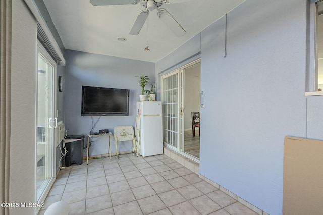 unfurnished sunroom with ceiling fan