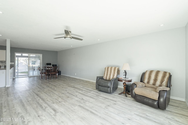 sitting room with ceiling fan and light wood-type flooring