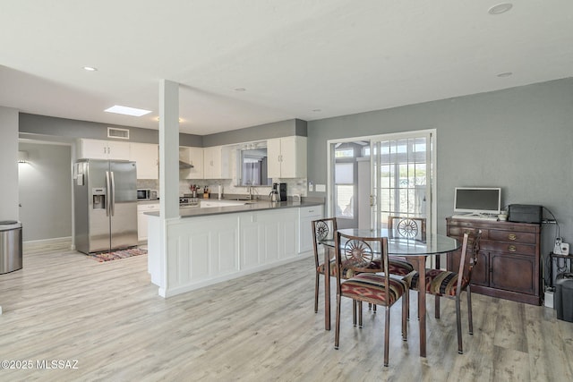 dining space with sink and light hardwood / wood-style flooring