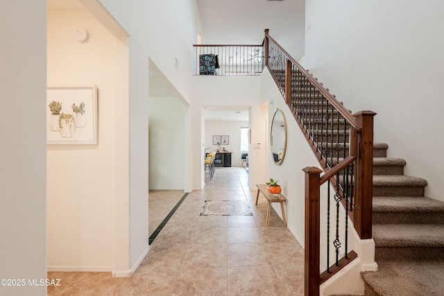 interior space featuring a towering ceiling and tile patterned flooring