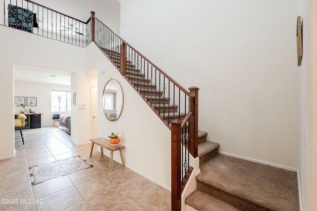 stairs with a high ceiling and tile patterned flooring