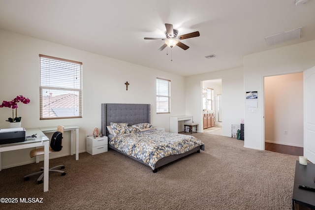 carpeted bedroom with ceiling fan and ensuite bath