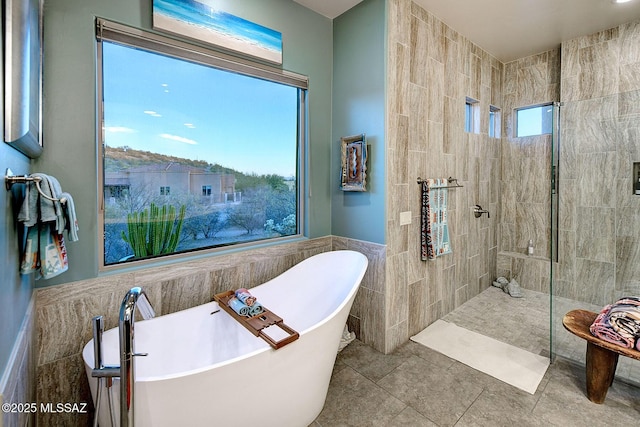 bathroom featuring separate shower and tub, tile walls, and tile patterned floors