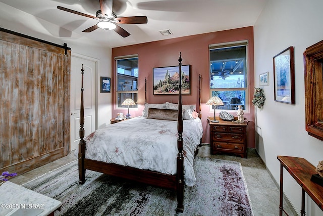 bedroom with ceiling fan and a barn door