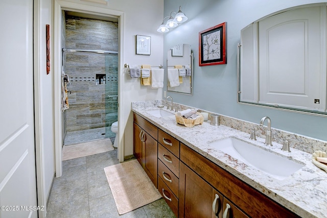 bathroom with vanity, tile patterned floors, a shower with door, and toilet