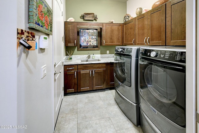 laundry area featuring cabinets, washing machine and dryer, sink, and light tile patterned flooring