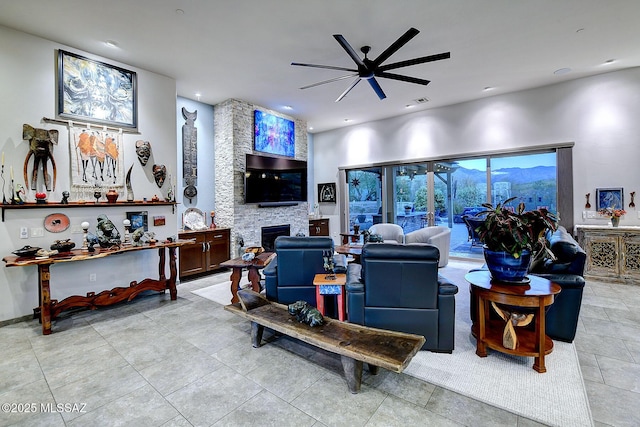 living room with a fireplace and ceiling fan