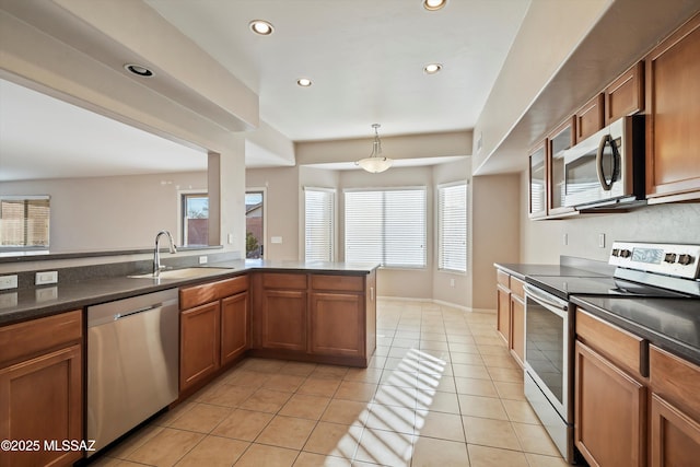 kitchen featuring sink, hanging light fixtures, light tile patterned floors, kitchen peninsula, and stainless steel appliances