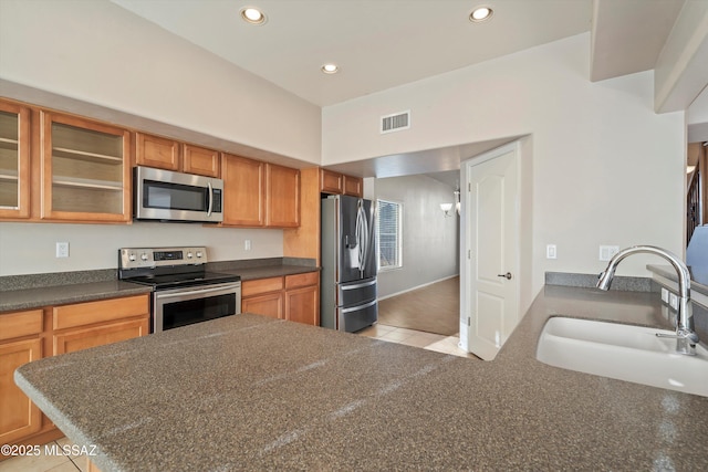 kitchen featuring sink, stainless steel appliances, kitchen peninsula, and light tile patterned flooring