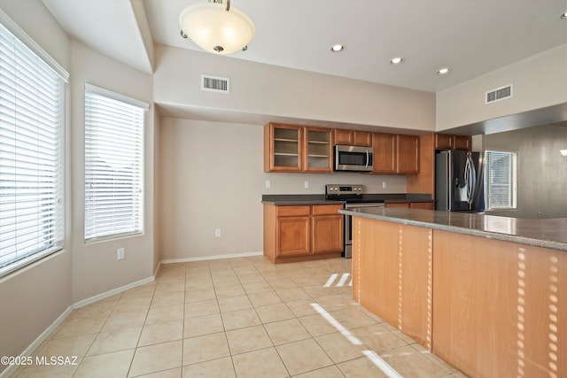 kitchen with light tile patterned floors, decorative light fixtures, and appliances with stainless steel finishes