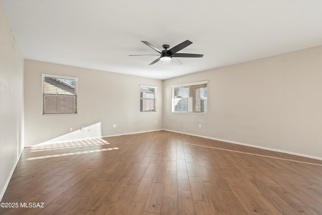 unfurnished room featuring ceiling fan, wood-type flooring, and a healthy amount of sunlight