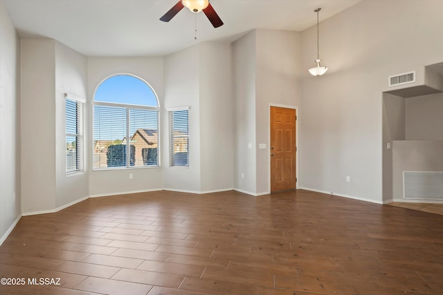 empty room with a high ceiling and dark hardwood / wood-style floors