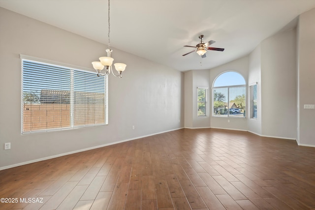 empty room featuring dark hardwood / wood-style flooring and ceiling fan with notable chandelier