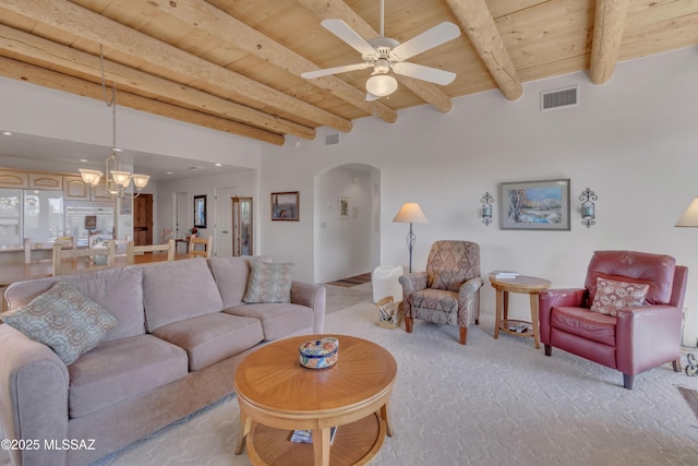 living room with wood ceiling, ceiling fan with notable chandelier, light carpet, and beamed ceiling