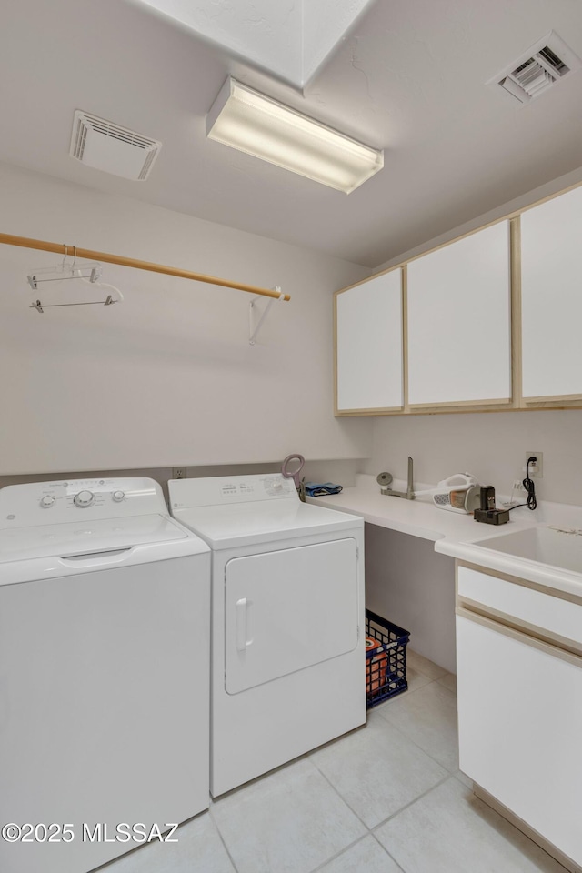 laundry room featuring sink, cabinets, washing machine and clothes dryer, and light tile patterned flooring