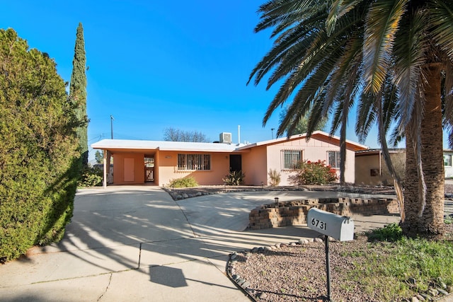 view of front of property featuring stucco siding, driveway, and an attached carport