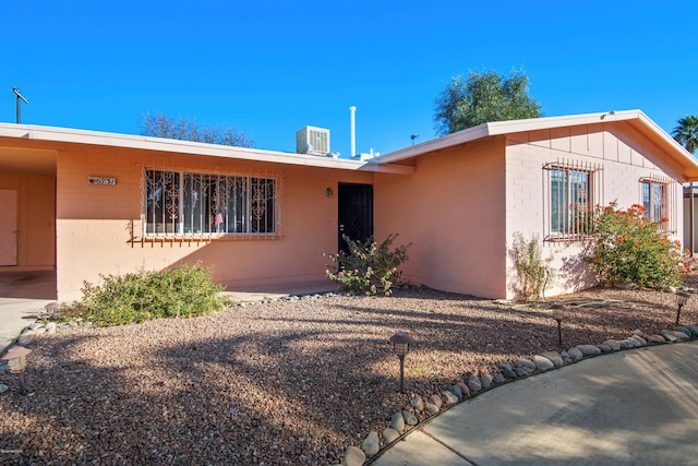 ranch-style house with concrete block siding and central AC