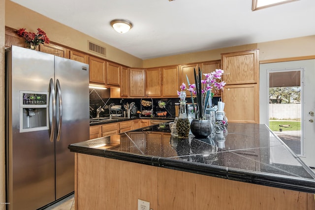 kitchen with backsplash, sink, kitchen peninsula, and stainless steel refrigerator with ice dispenser