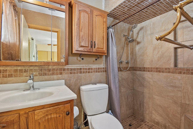 bathroom featuring tile walls, vanity, toilet, and walk in shower