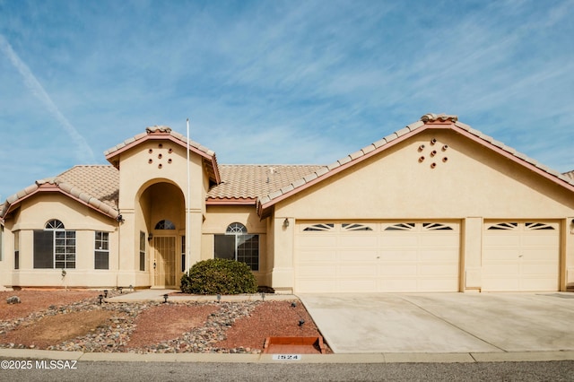 1524 W Sunridge Dr, Tucson, AZ 85704 - mediterranean / spanish-style home featuring concrete driveway, an attached garage, a tile roof, and stucco siding