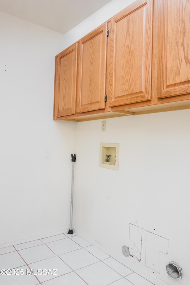 clothes washing area with cabinets, hookup for a washing machine, and light tile patterned floors