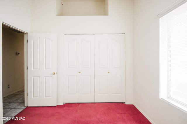 unfurnished bedroom featuring a closet and light carpet