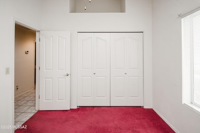 unfurnished bedroom with multiple windows, light colored carpet, and a closet