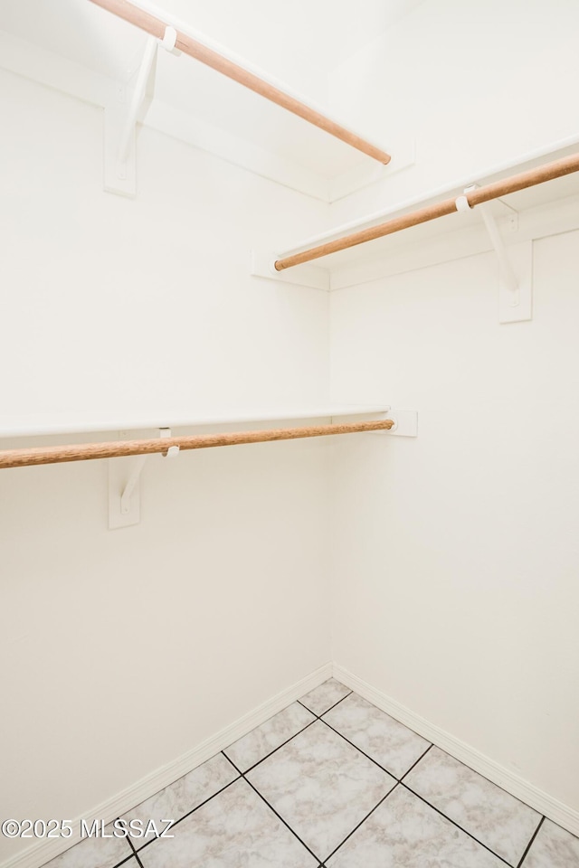 spacious closet with light tile patterned floors