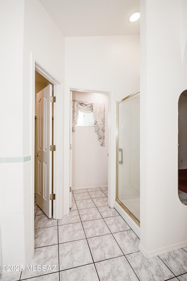 bathroom featuring an enclosed shower and tile patterned flooring