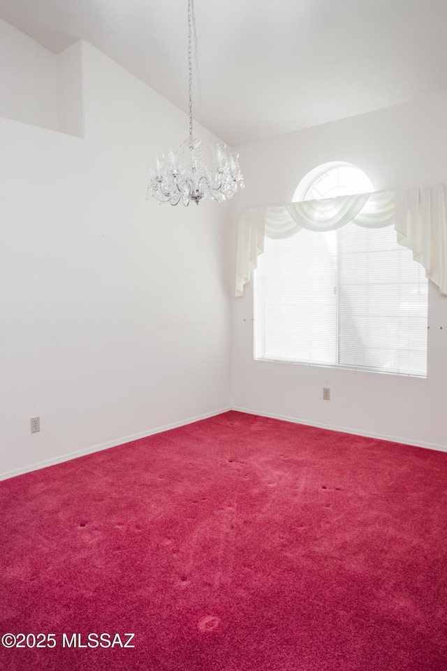 carpeted spare room with lofted ceiling and a chandelier