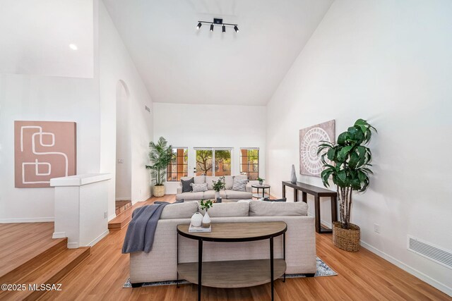 living room with ceiling fan, tile patterned floors, and high vaulted ceiling