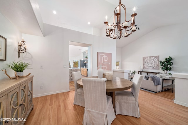 dining area featuring a notable chandelier, light wood-style flooring, recessed lighting, baseboards, and vaulted ceiling