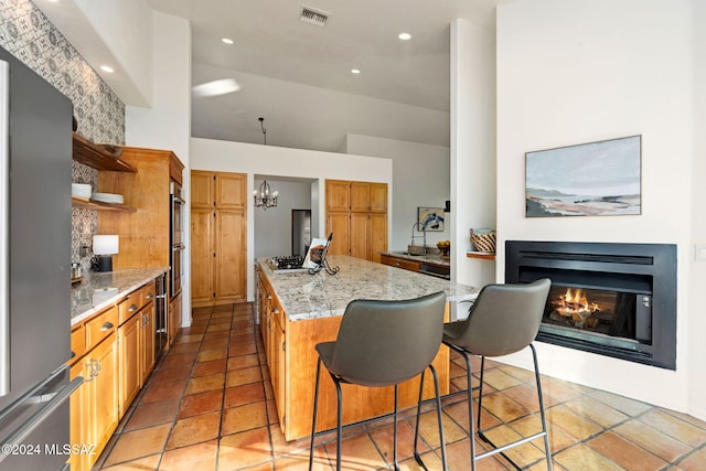 kitchen featuring visible vents, open shelves, a kitchen island, a glass covered fireplace, and appliances with stainless steel finishes