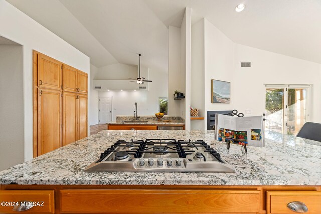 kitchen featuring a breakfast bar area, light stone counters, a notable chandelier, stainless steel appliances, and a kitchen island with sink