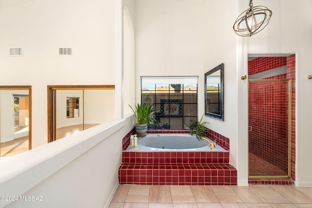 bathroom featuring visible vents, a shower stall, a high ceiling, and a garden tub