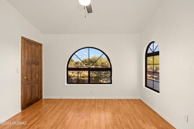 unfurnished room with baseboards, light wood-style floors, and a ceiling fan